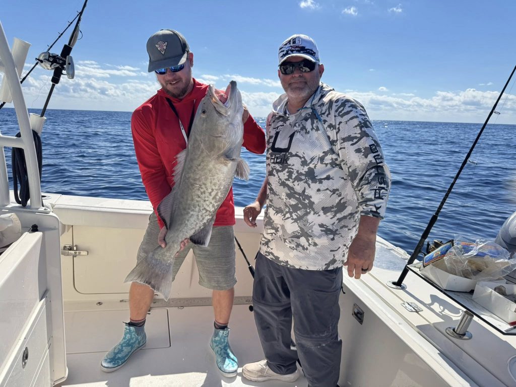 Veterans showing off their catch on a boat during their fishing trip