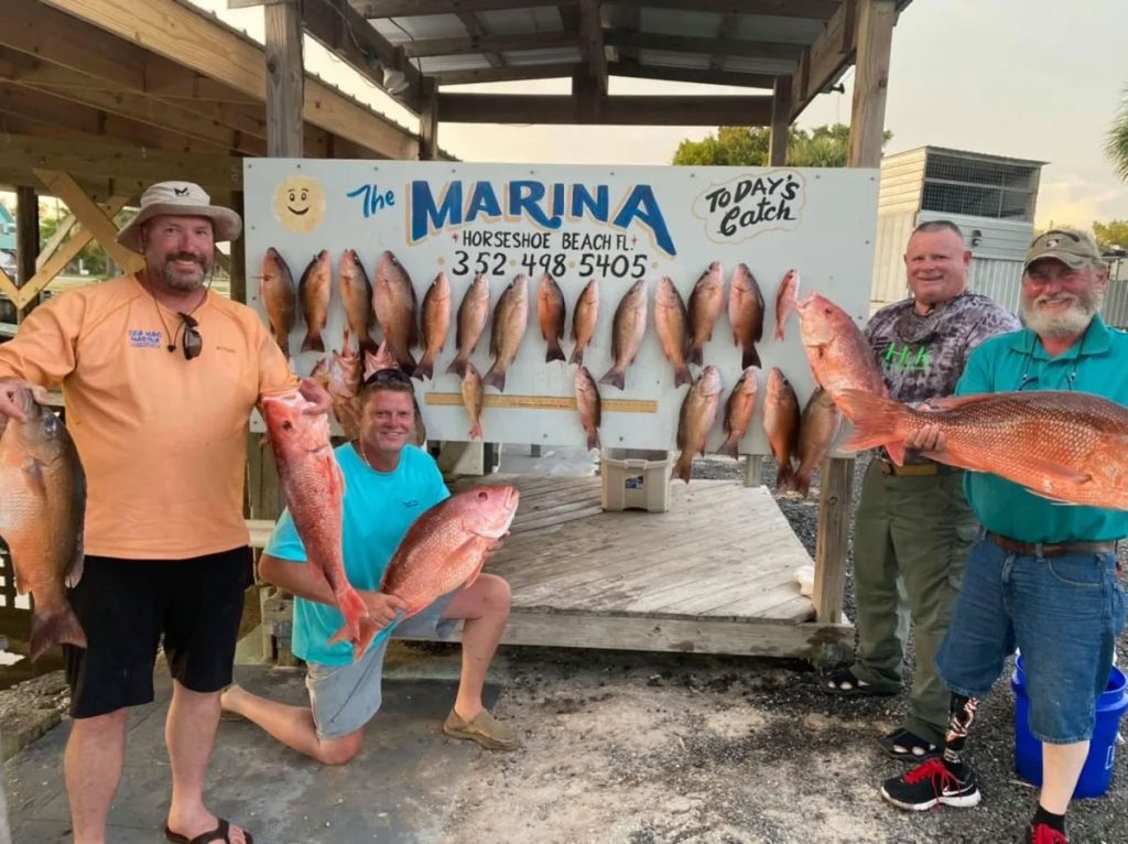 Veterans showing off their catches from their fishing trip
